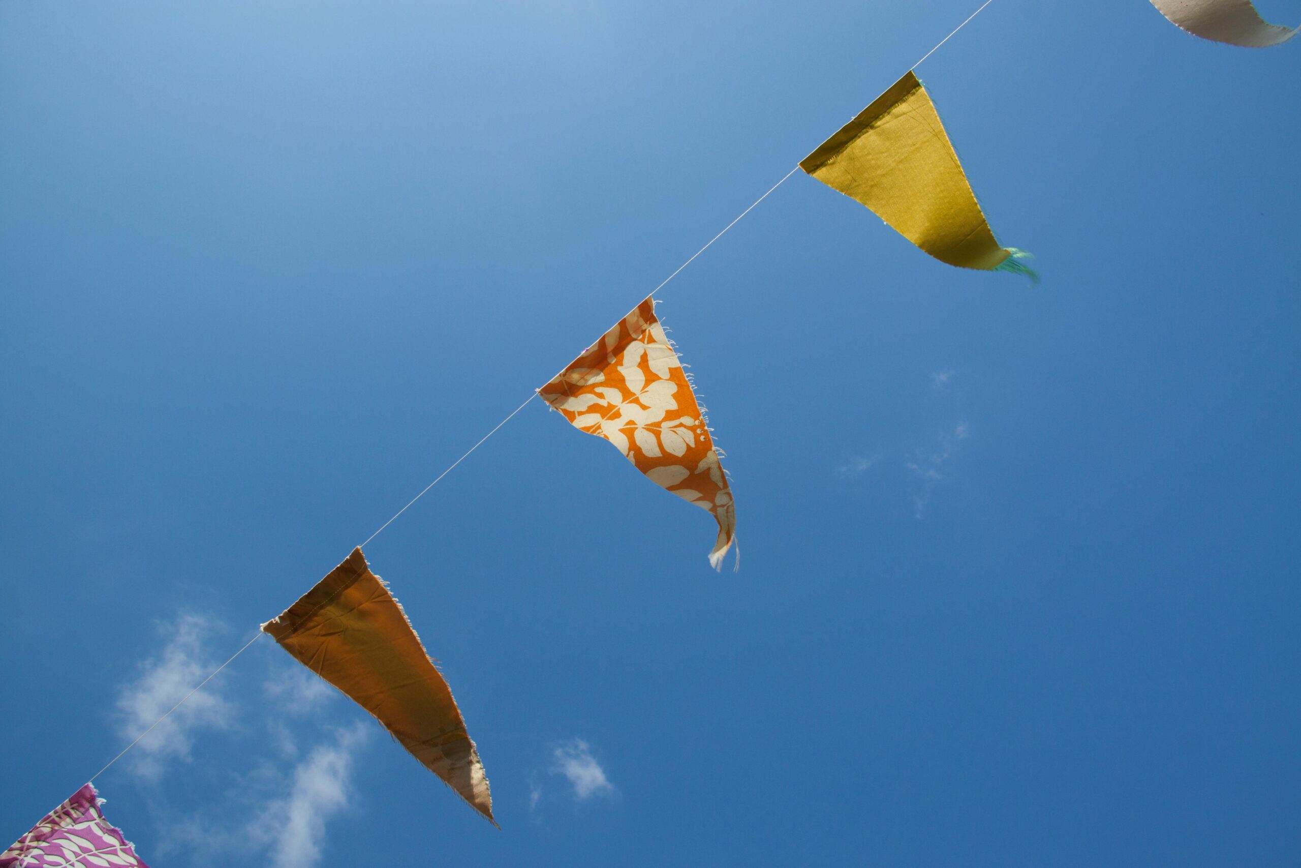 Orange yellow and red flaglets under blue white sky during daytime